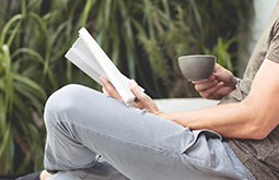 Homme lisant un livre en buvant un thé, représentant la catégorie livres dans le e-shop de CapRol